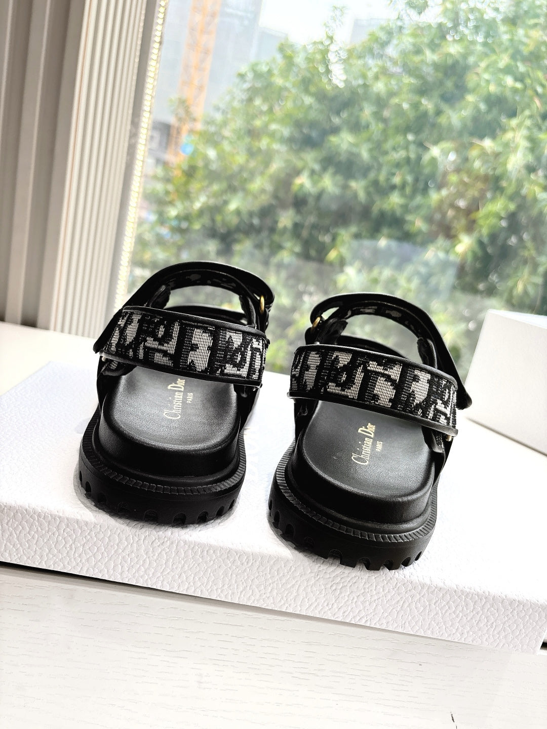 Black Dior sandals with monogram straps and low-profile treaded sole