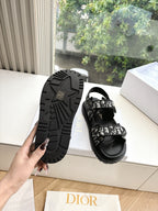 Black Dior sandals showing treaded outsole and patterned strap detailing