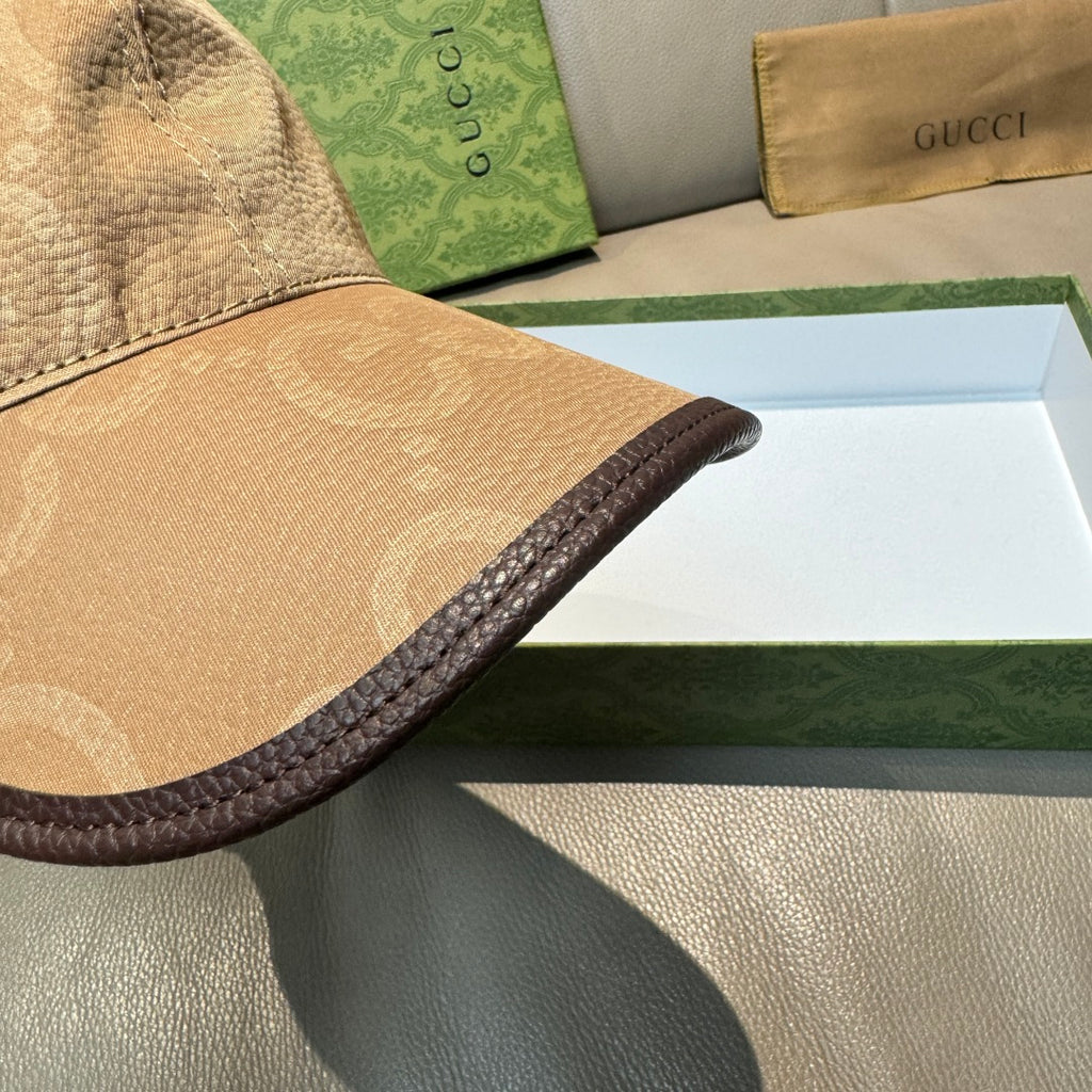 Gucci GG baseball cap close-up showing dark piping along brim edge and monogram texture