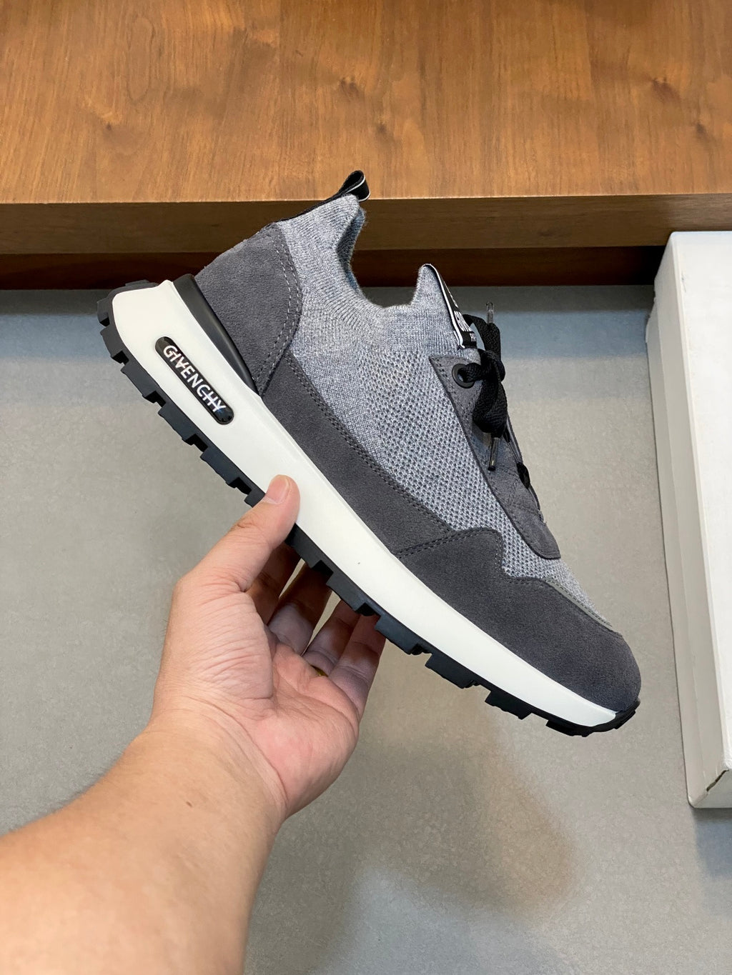 Givenchy gray sneakers with black laces, stitched logo patch, and white sole