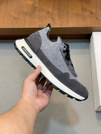 Givenchy gray sneakers with black laces, stitched logo patch, and white sole
