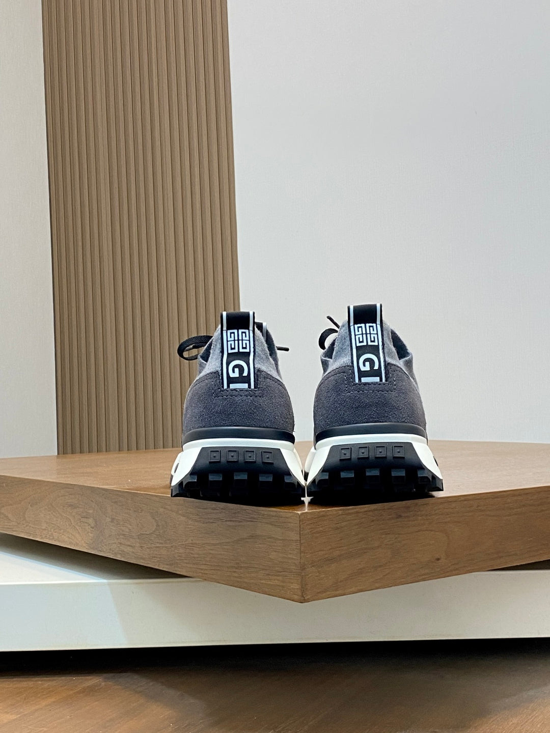 Givenchy sneakers rear view with gray uppers, black heel tabs, and tread sole