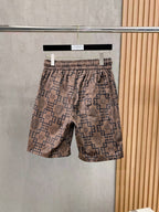 Elastic-waist drawstring shorts with beige base and navy Greek key Medusa print