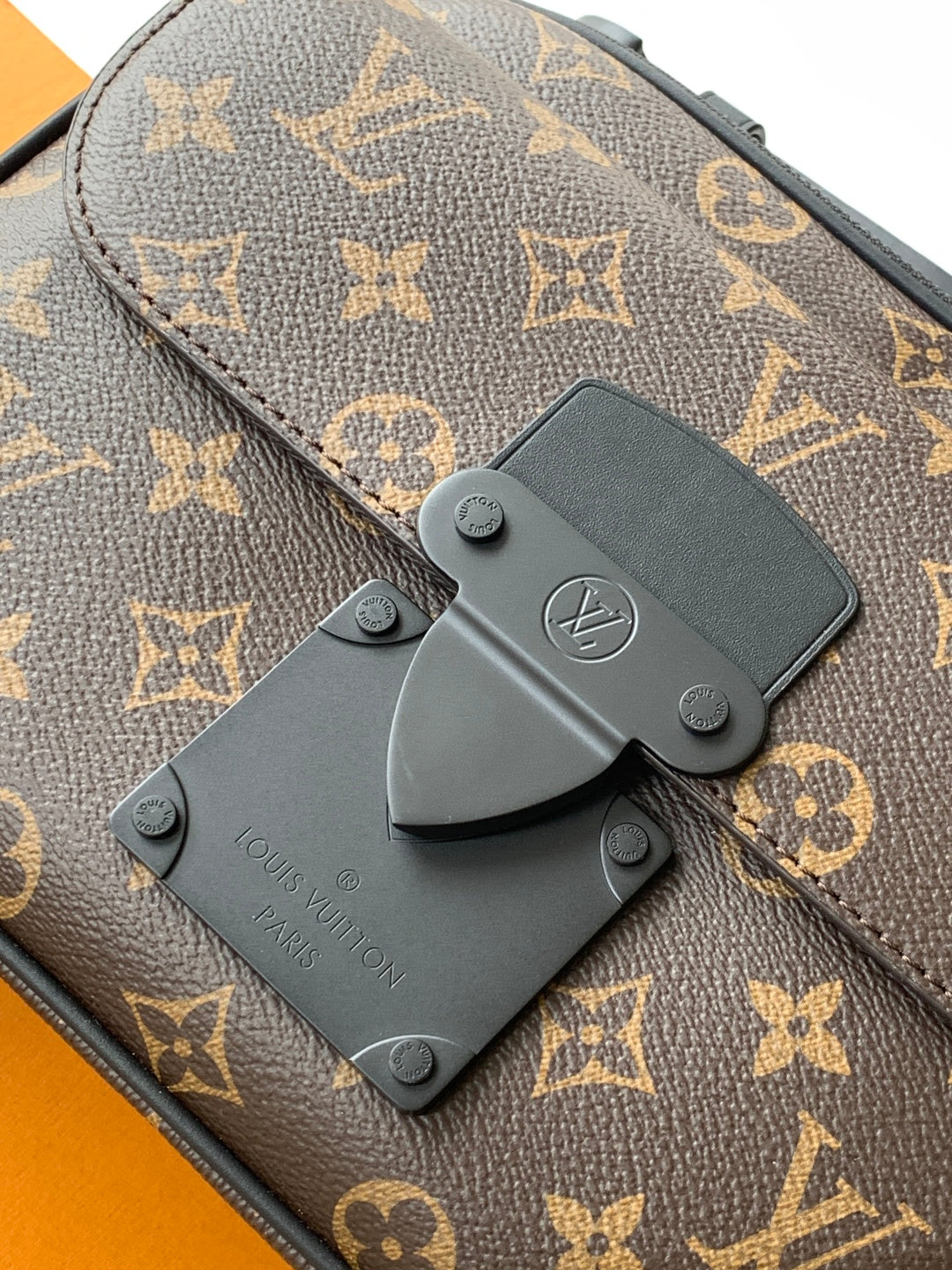 Louis Vuitton monogram bag close-up of dark leather flap with LV logo patch