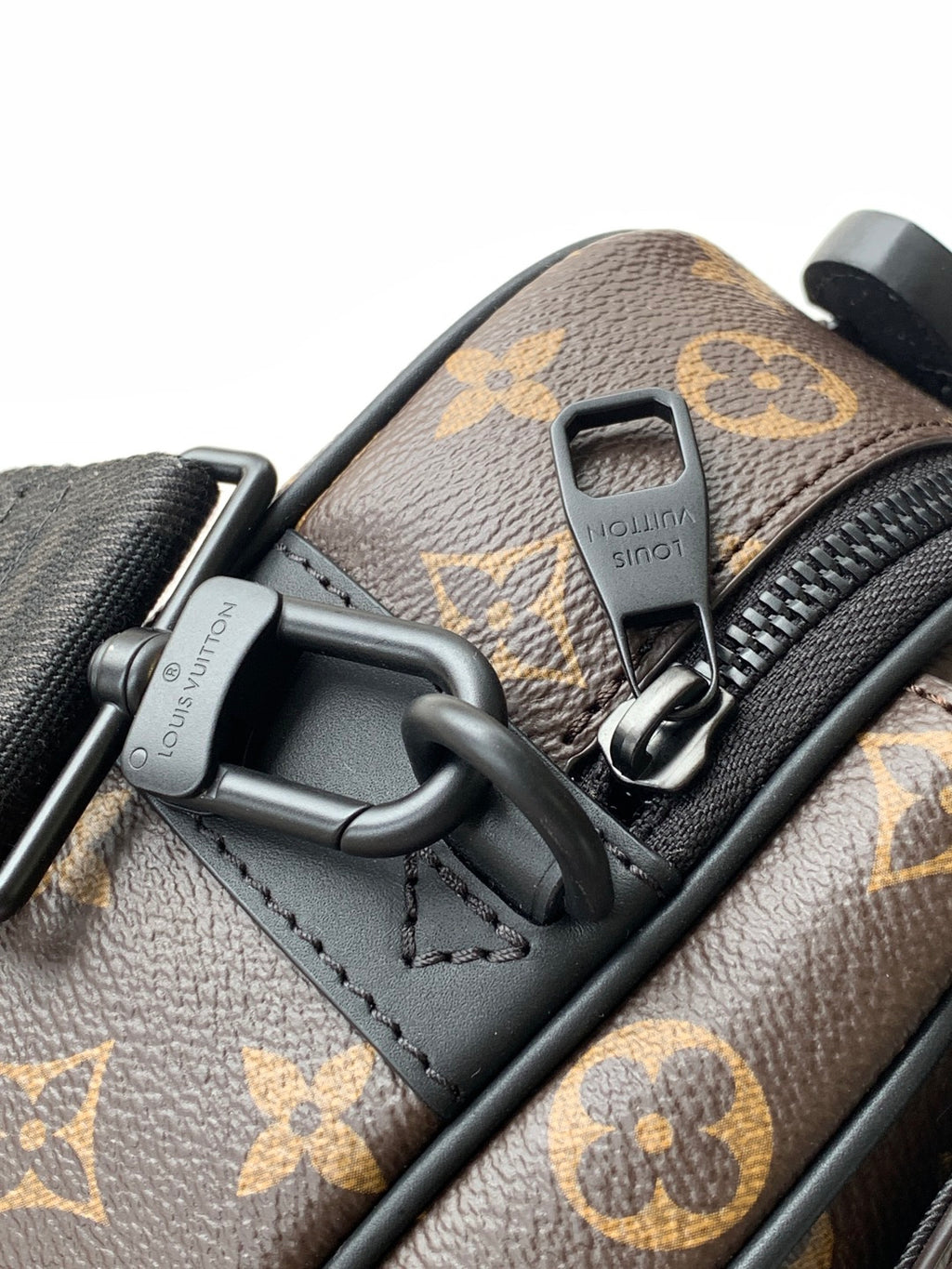 Louis Vuitton monogram bag close-up of black D-ring hardware and zipper pull