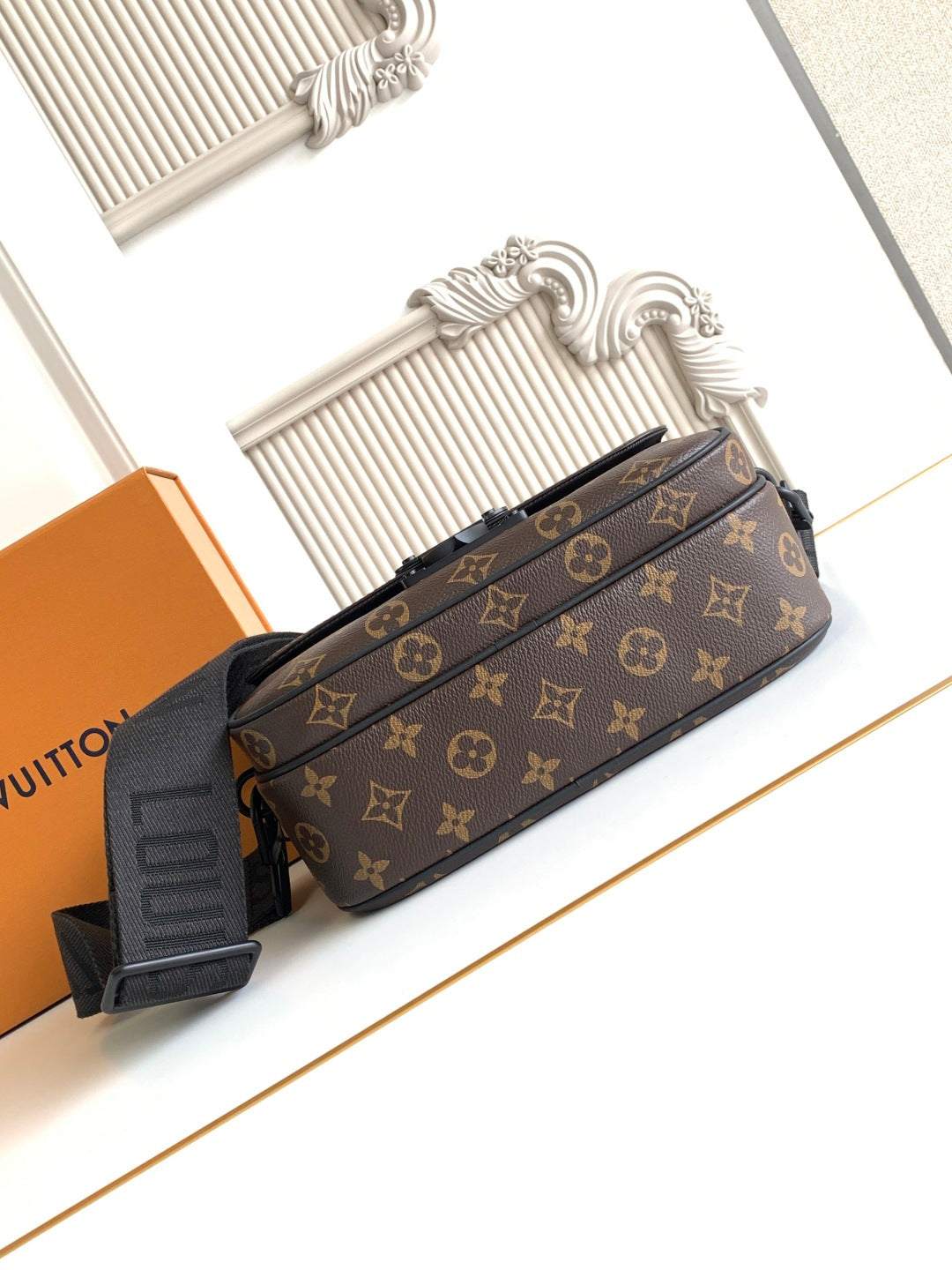 Louis Vuitton monogram crossbody bag with front flap and strap, profile view with zipper