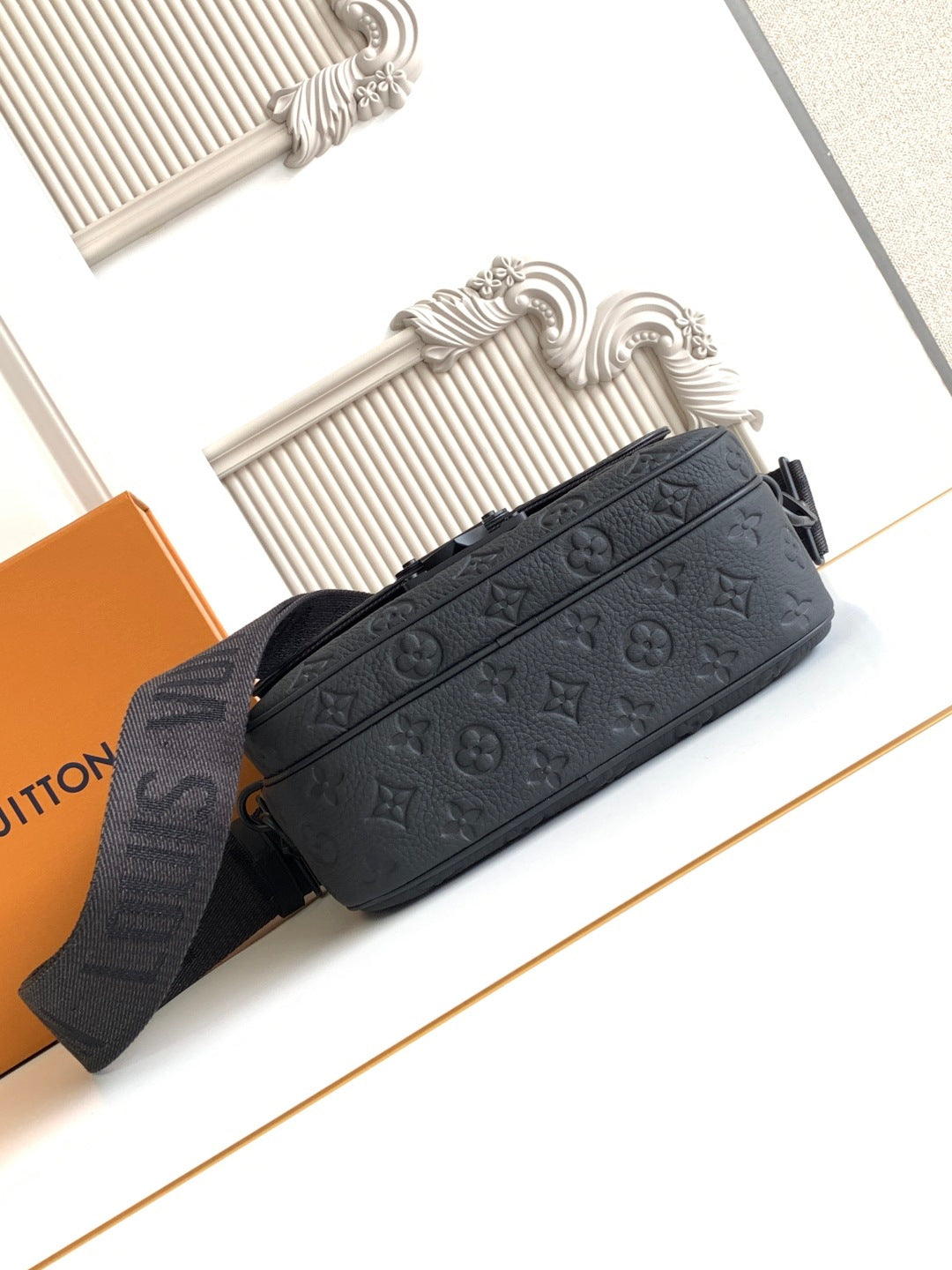 Louis Vuitton monogram crossbody bag, dark, with adjustable strap and structured silhouette