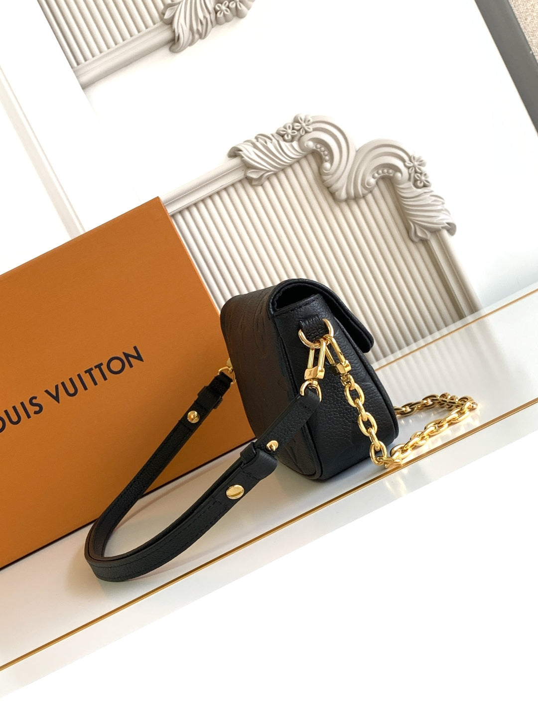 Black leather mini flap shoulder bag with gold chain strap and side button