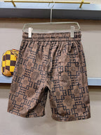 Allover logo-pattern shorts on hanger, elastic waist, tan fabric with navy geometric print
