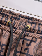 Drawstring shorts with beige fabric, navy pattern, and gold-tone eyelet tips