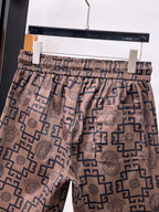 Elastic-waist drawstring shorts in beige with navy Greek key and Medusa icons