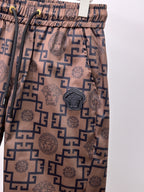 Beige shorts with navy medallion applique and scattered Greek key icons