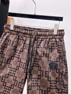 Elastic-waist drawstring shorts with beige and navy Medusa and Greek key pattern