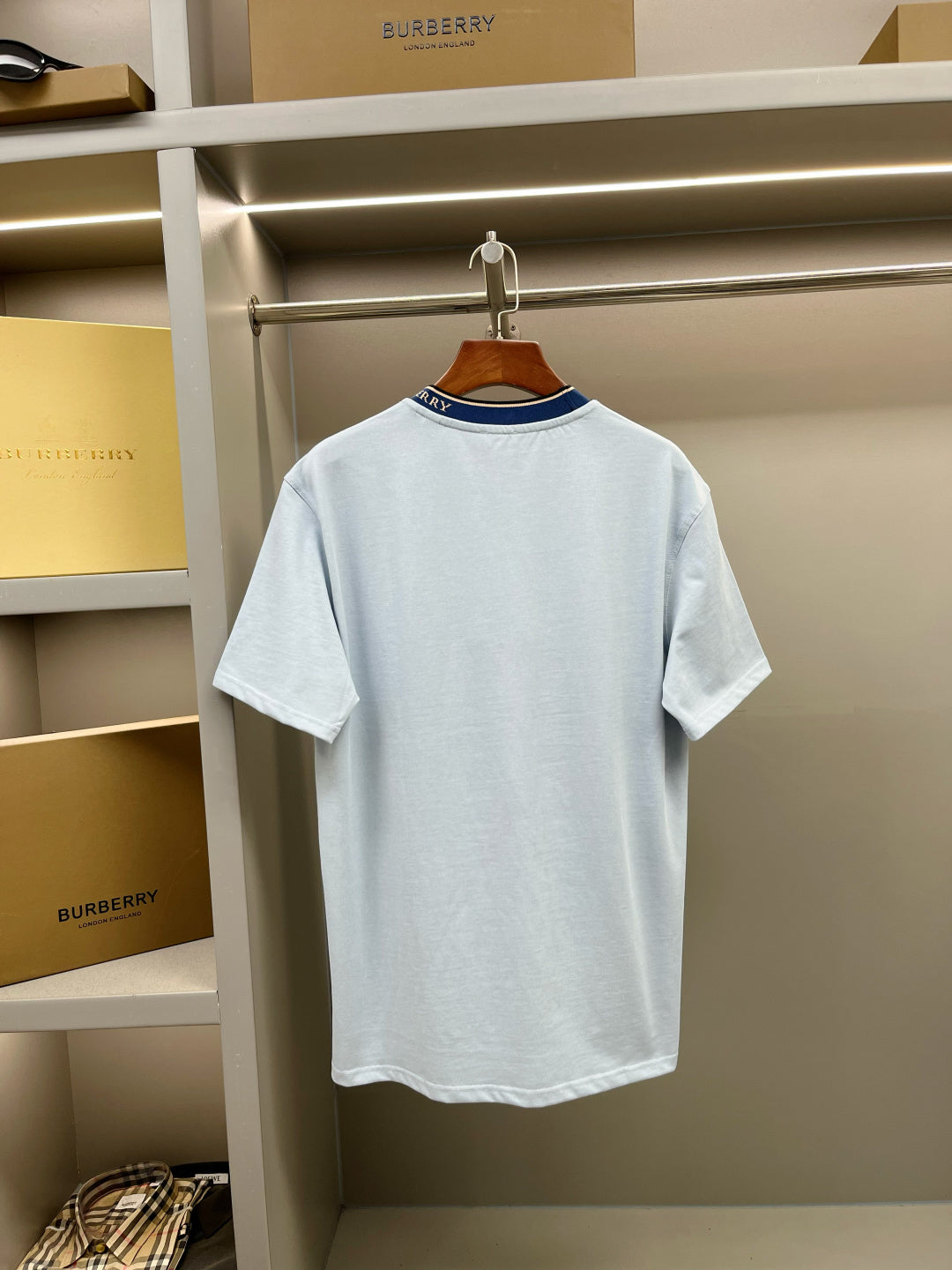 Light blue Burberry crew-neck T-shirt with navy ribbed collar and short sleeves.