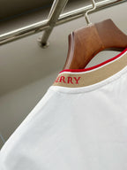 Close-up of white T-shirt shoulder and tan collar trim with red stripe and Burberry text.