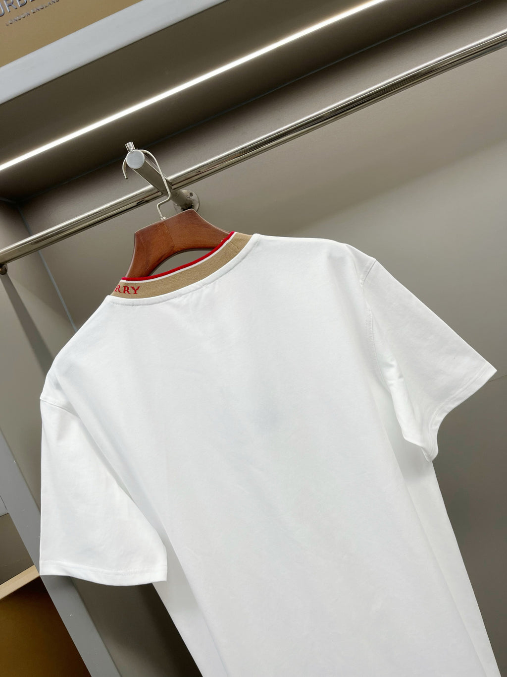 White short-sleeve T-shirt back view with tan collar trim and small logo placement.