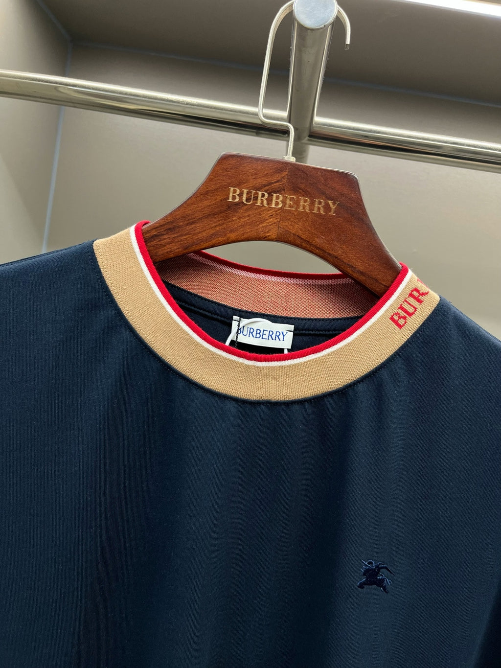 Navy Burberry T-shirt neckline detail with beige ribbed collar and red trim
