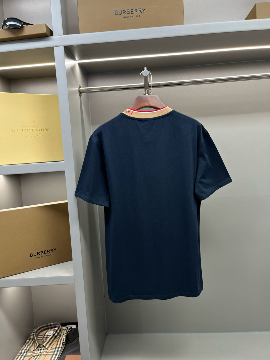 Burberry navy short-sleeve top front view with beige ribbed collar and red trim