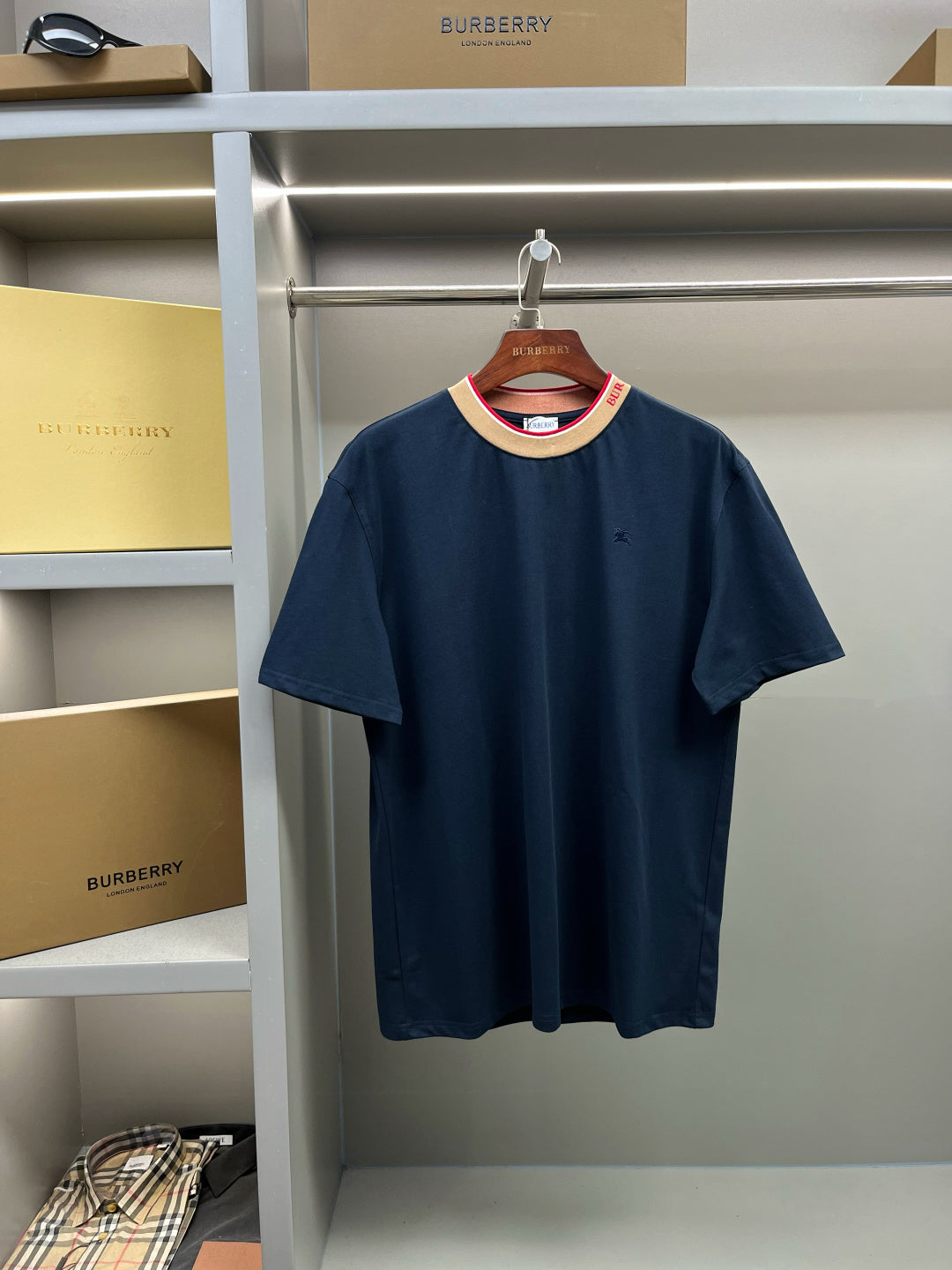 Burberry navy short-sleeve top with beige ribbed collar and red trim, small chest logo