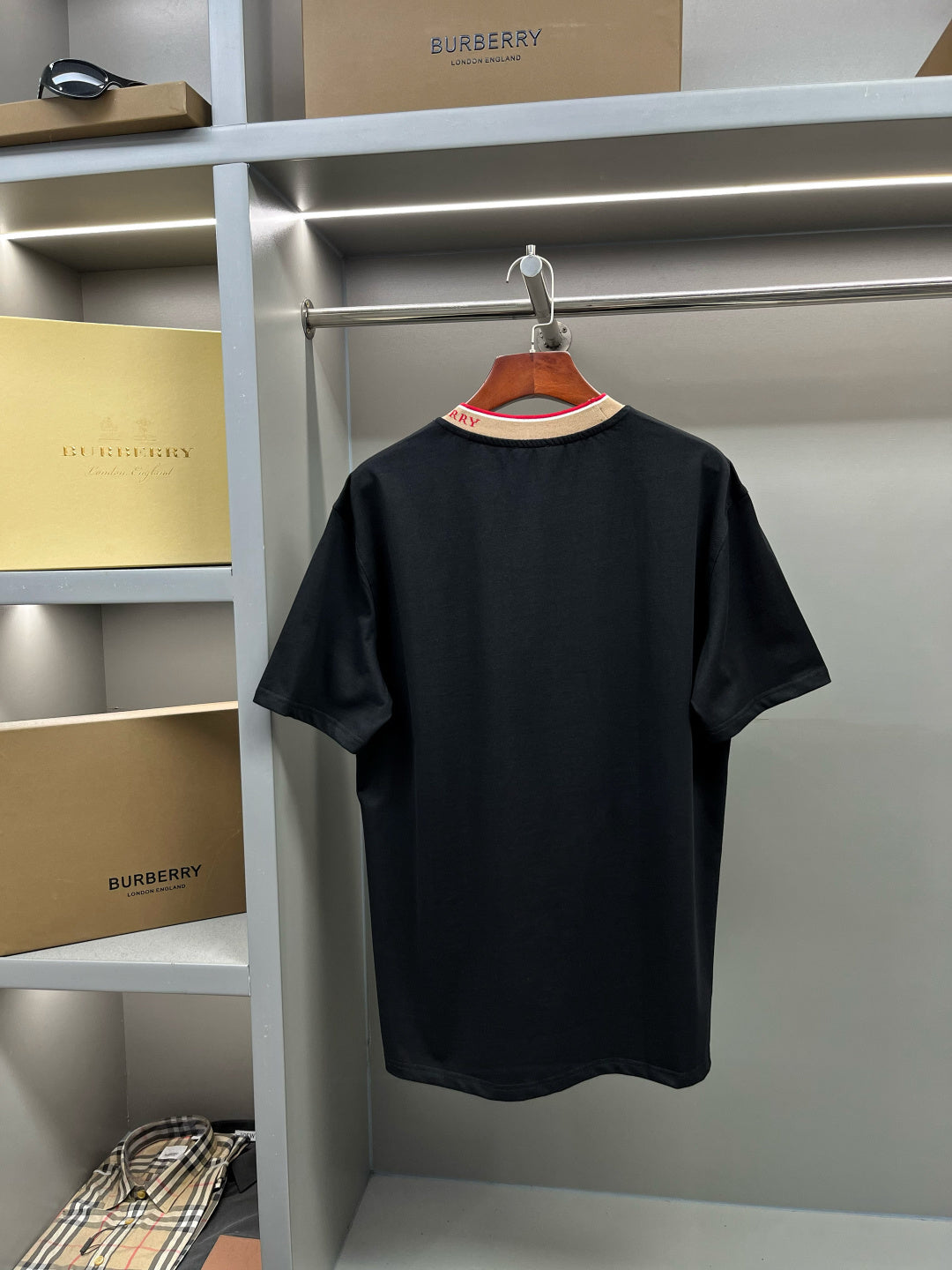 Black Burberry T-shirt on hanger with ribbed crew neck and multicolor trim.