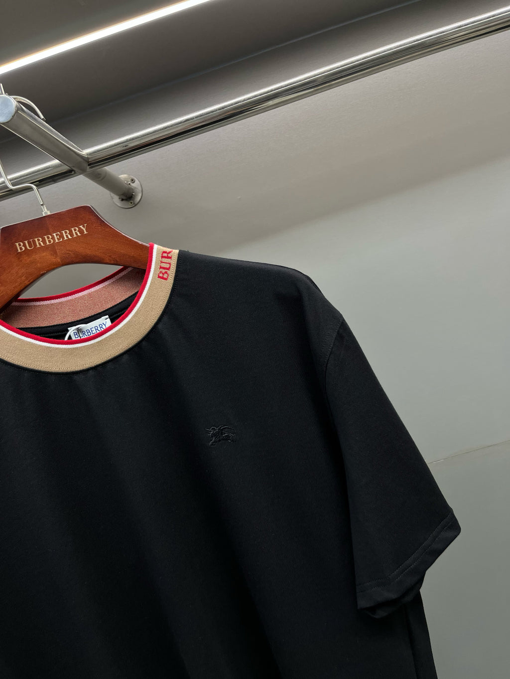 Black Burberry T-shirt close-up: collar trim and small chest logo.