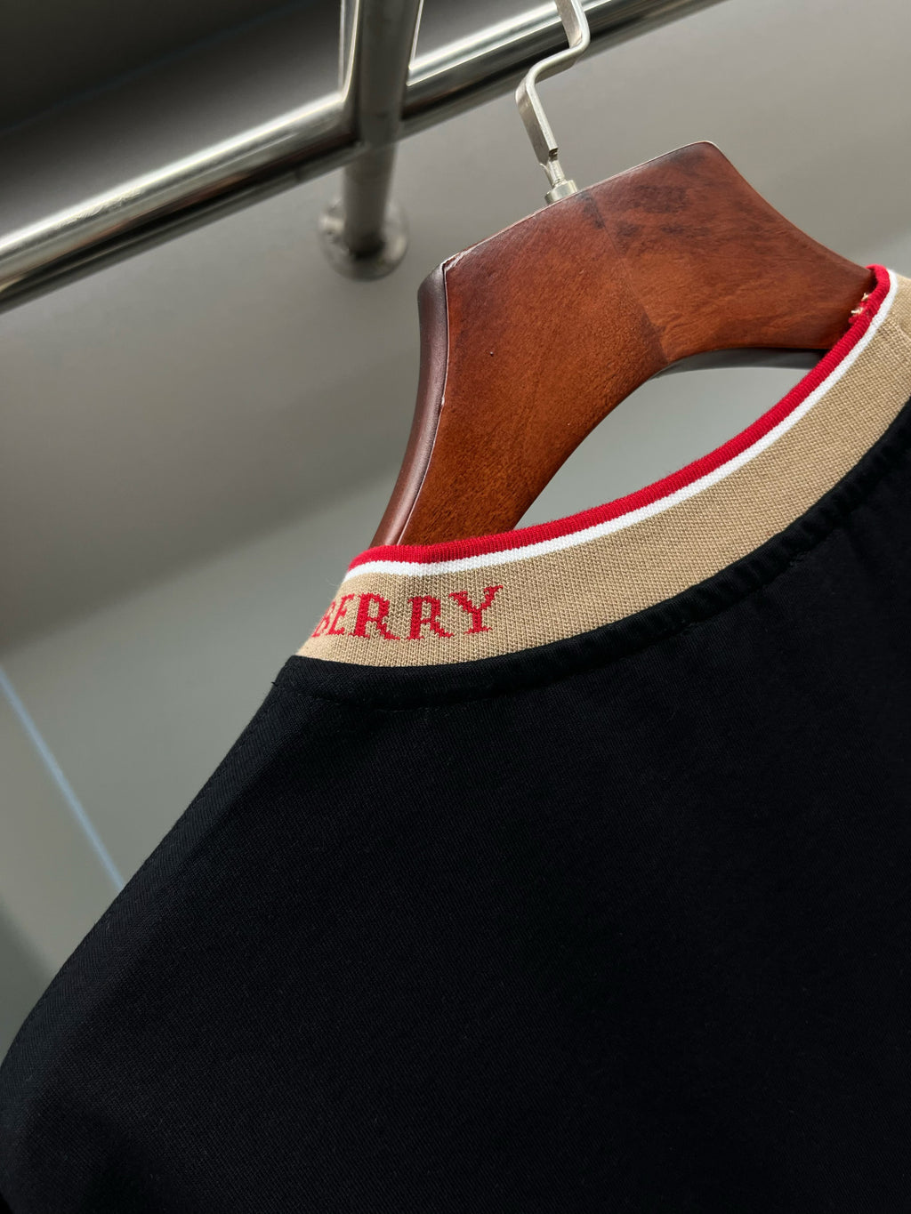 Burberry black crew-neck shirt with beige collar band and red “BURBERRY” lettering