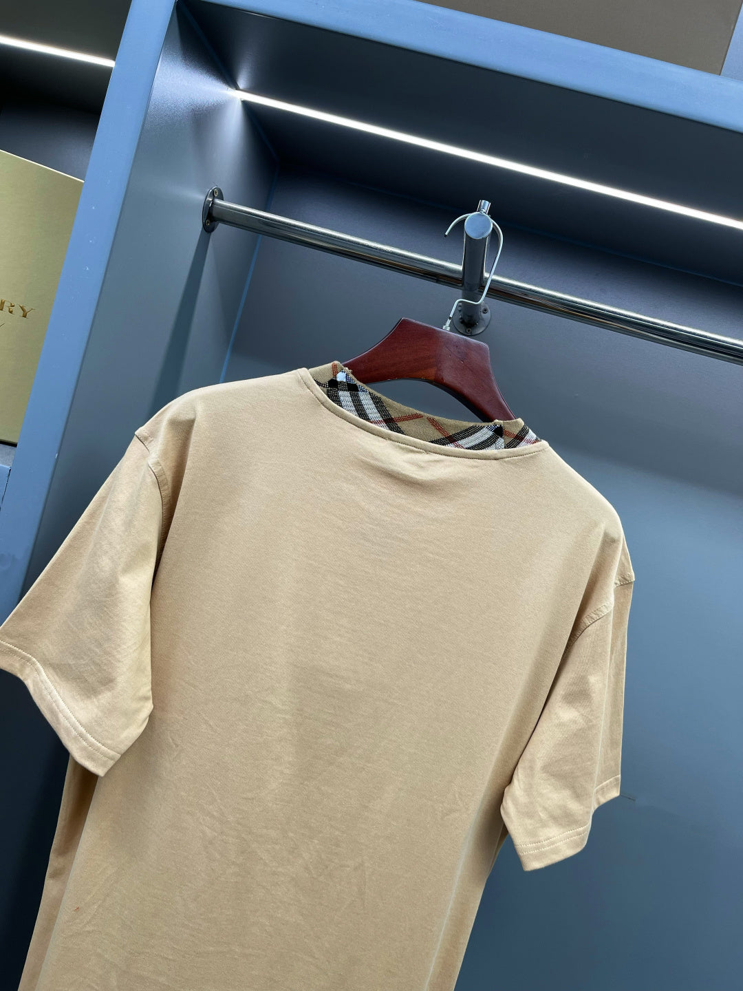 Beige short-sleeve T-shirt with crew neck and plaid trim at collar