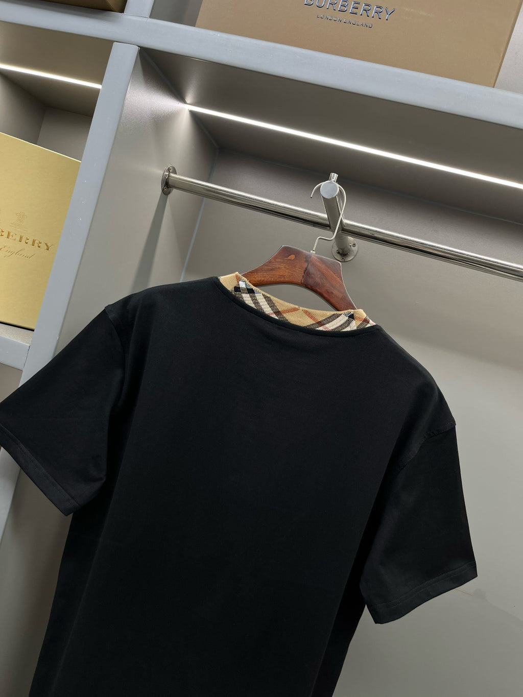Burberry black short-sleeve top with plaid inner collar trim at neckline