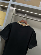 Burberry black short-sleeve top with plaid inner collar trim at neckline