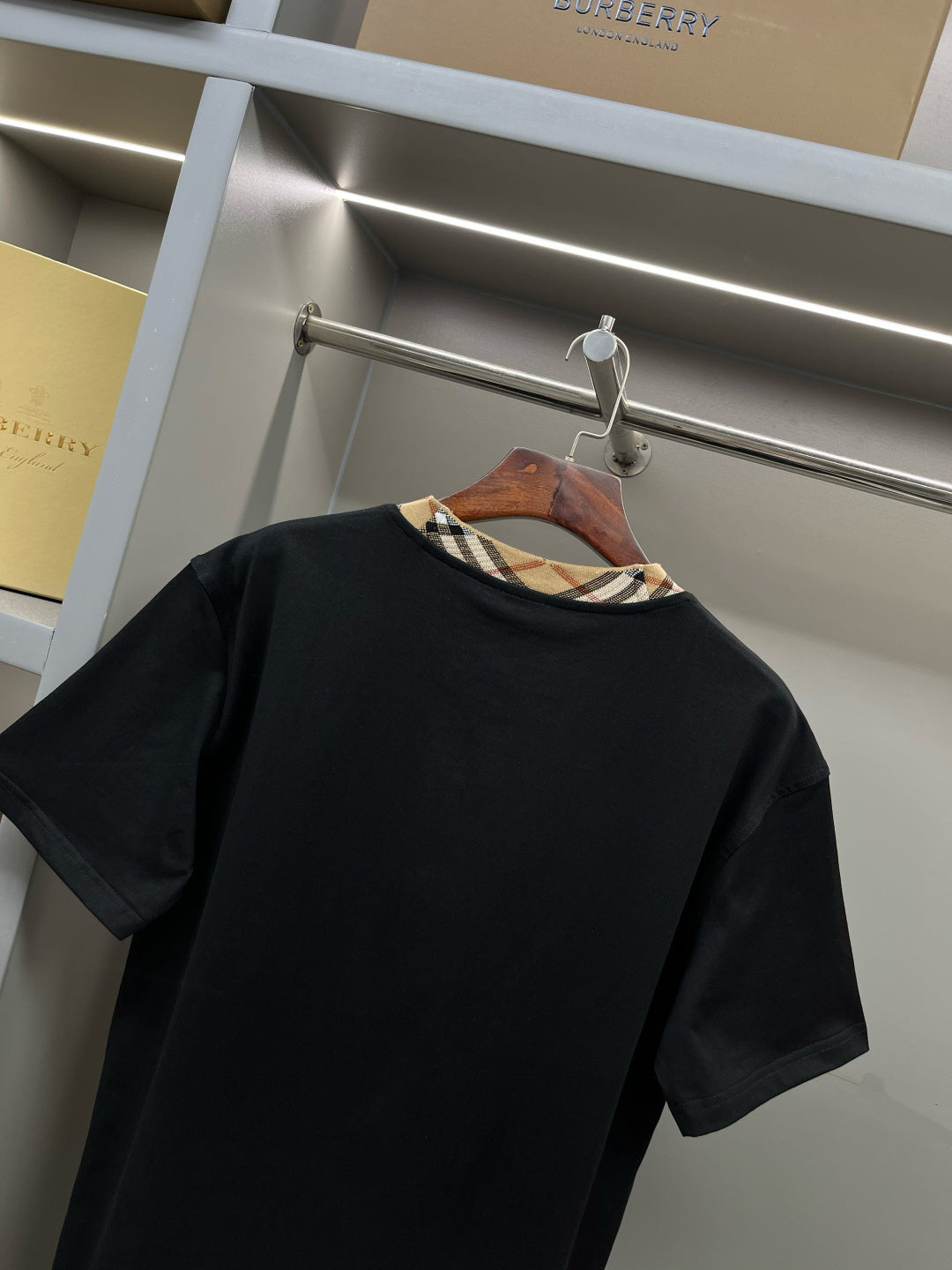 Burberry black short-sleeve top with plaid inner collar trim at neckline