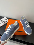 Blue suede lace-up sneakers with white laces and low rubber sole
