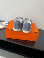 Pair of blue suede sneakers with white laces and padded heel tabs