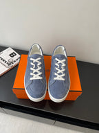 Blue suede lace-up sneakers with white eyelets and rubber sole