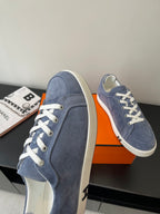 Blue suede sneaker with white laces and flat rubber sole
