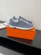 Blue suede low-top lace-up sneakers with white laces and trim