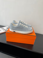 Hermes light blue low-top sneakers with white lace-up closure and side panel