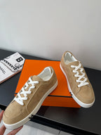 Hermes ladies low-top sneakers, tan suede, front quarter view with white laces