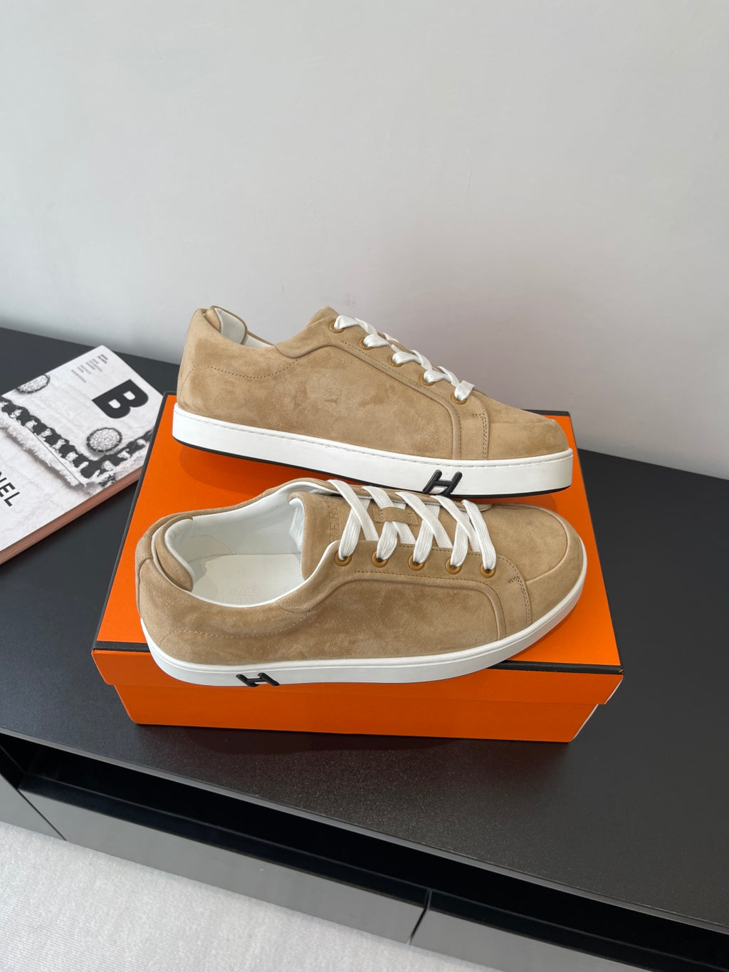Hermes ladies tan suede sneakers on box, one showing sole and laces