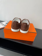 Brown suede low-top sneakers with white laces and white rubber heel