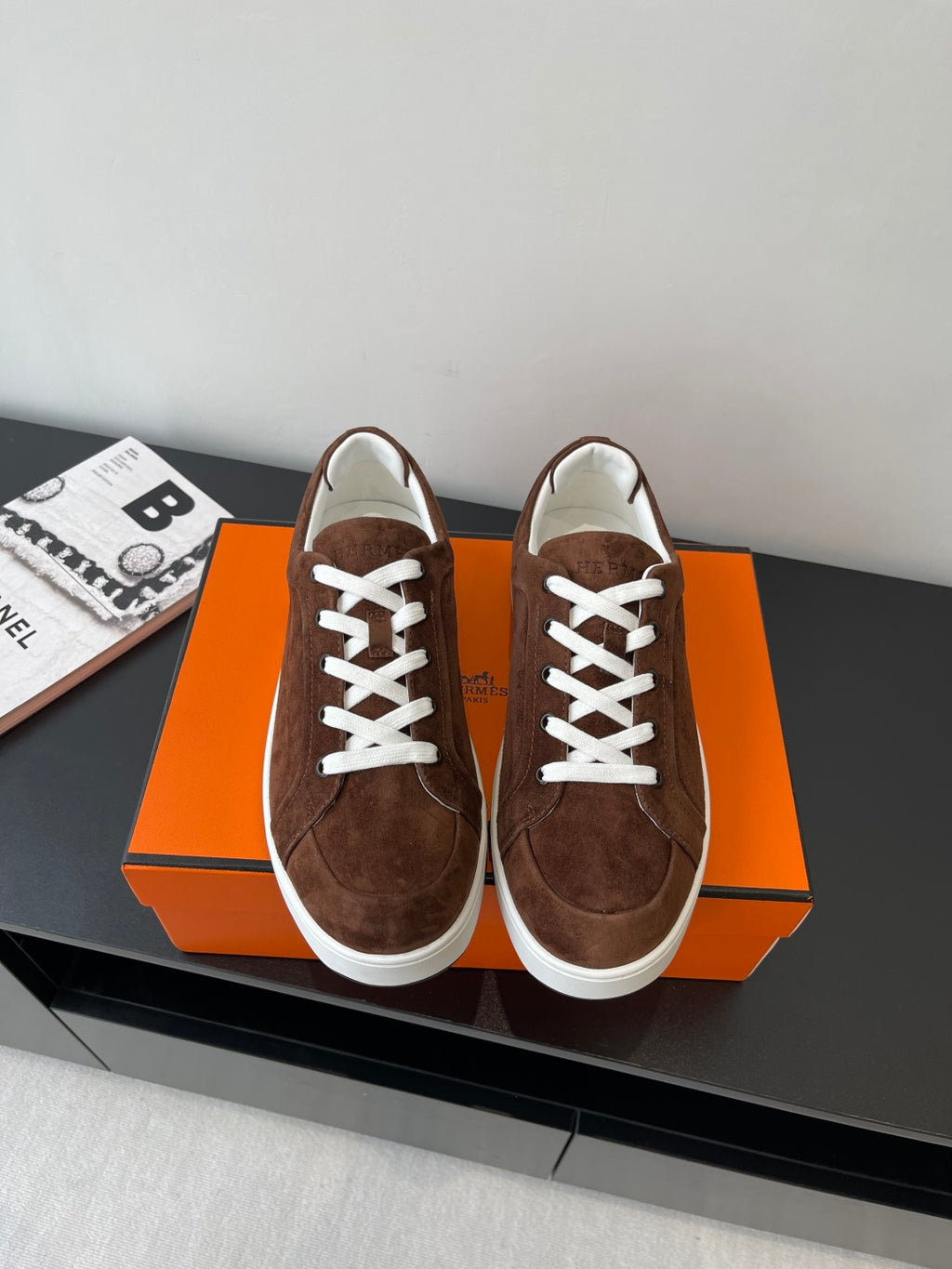 Brown suede low-top sneakers with white laces and white rubber trim