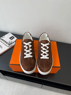 Brown suede low-top sneakers with white laces and white rubber trim