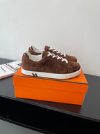 Brown suede low-top sneakers with white laces and thick white rubber sole