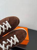 Brown suede low-top sneakers with white laces and white rubber soles