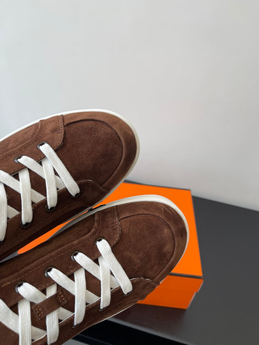 Brown suede low-top sneakers with white laces and white rubber soles