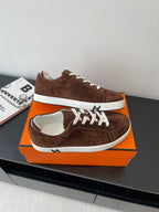 Brown suede low-top sneakers with white laces and white stripe midsole