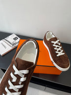 Brown suede low-top sneakers with white laces and padded white-trim collar