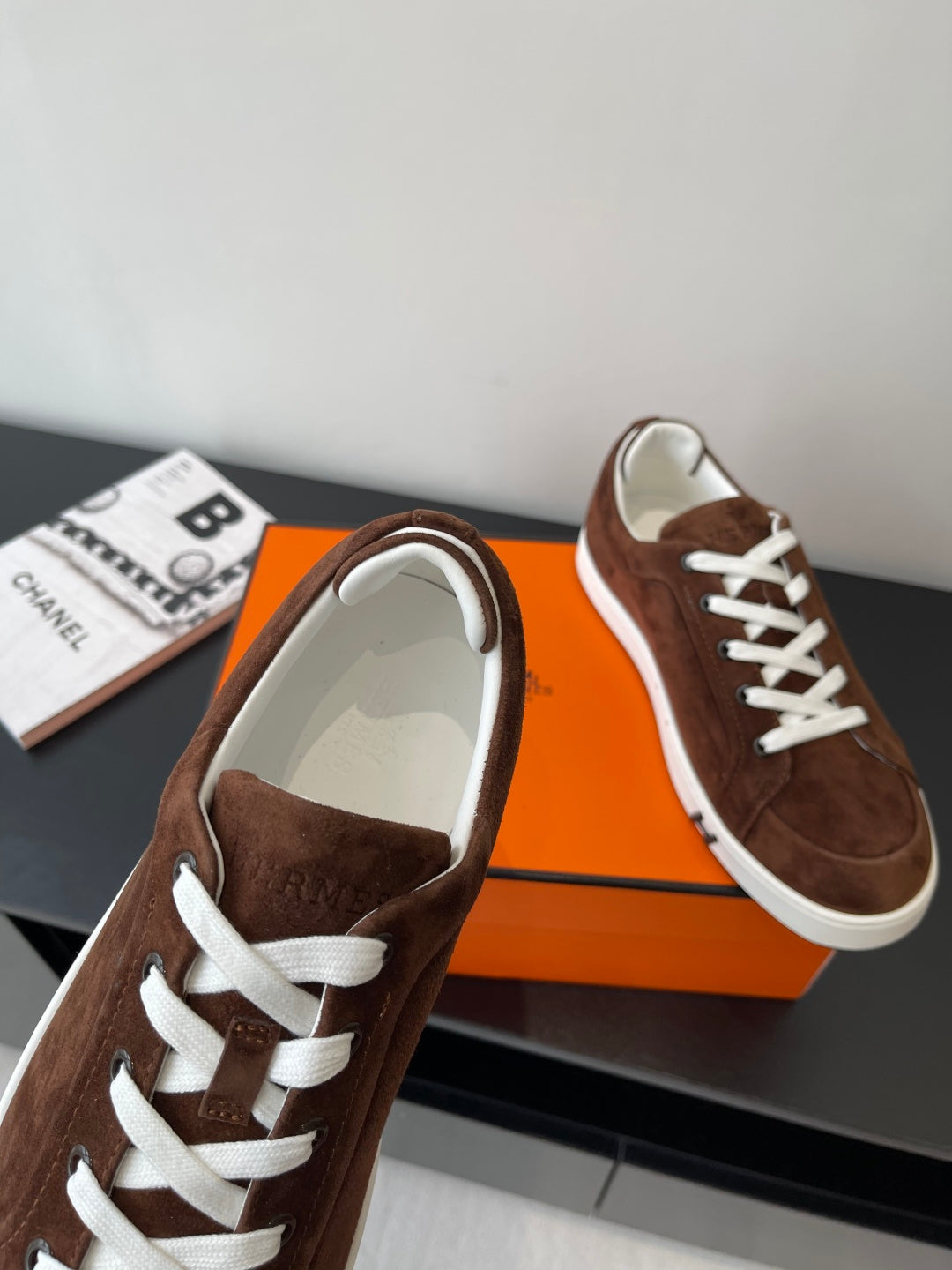 Brown suede low-top sneakers with white laces and padded white-trim collar