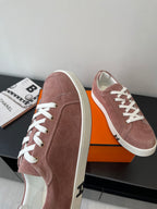 Hermes ladies suede sneakers angled view in dusty rose with white rubber side stripe
