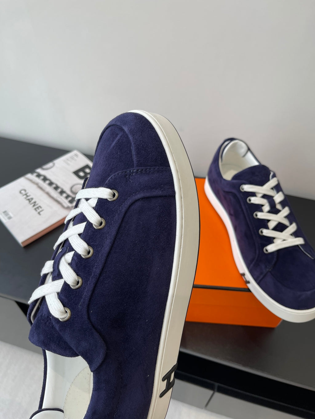 Hermes women's navy suede sneakers with white laces and thick white sole, side view