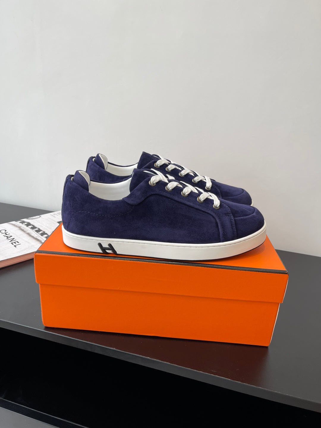 Hermes women's low-top sneakers in navy suede with white lace-up; side view